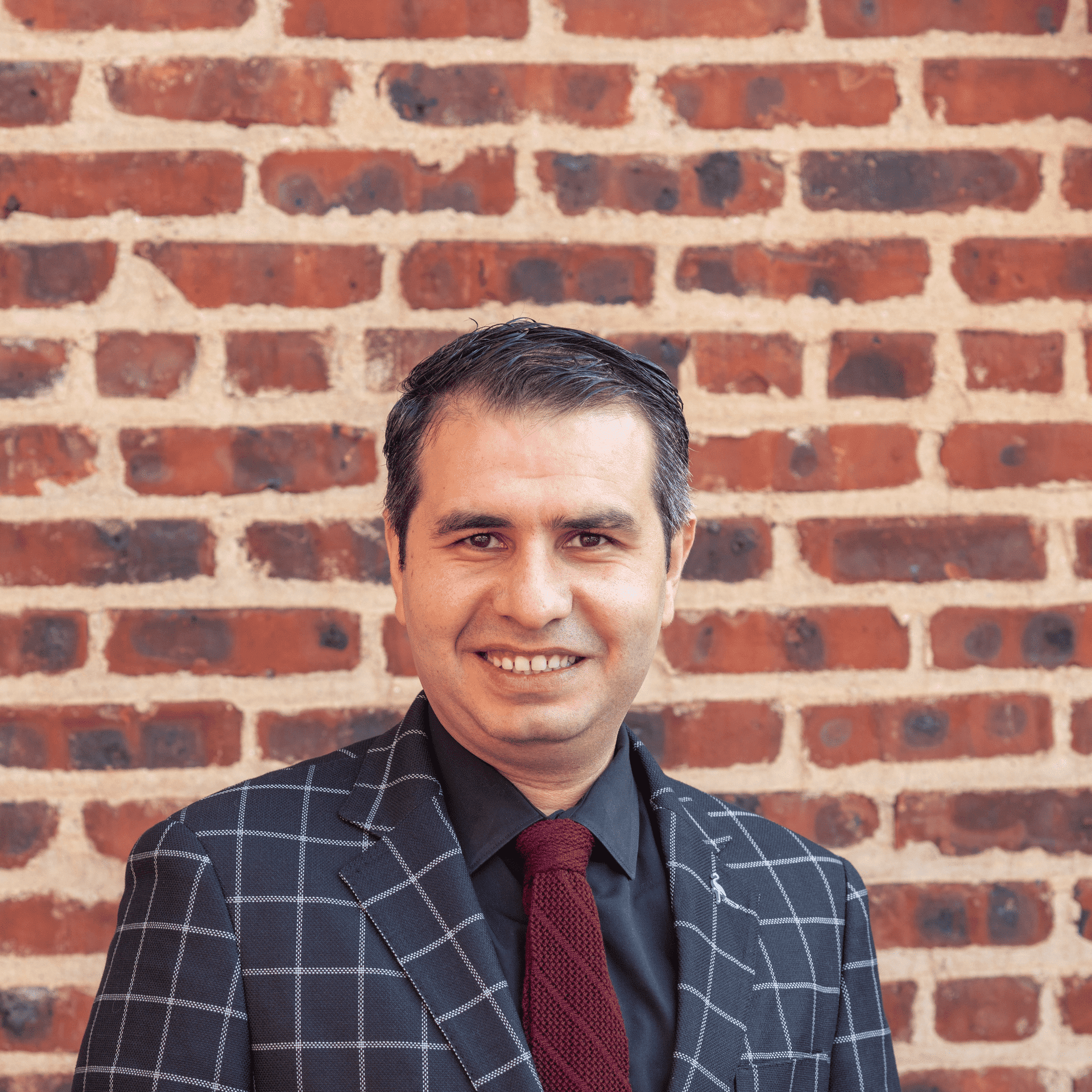 Portrait of Rimon Ebrahim, a professional stylist at Avalon Salon for Hair and Nails, showcasing their expertise and style.