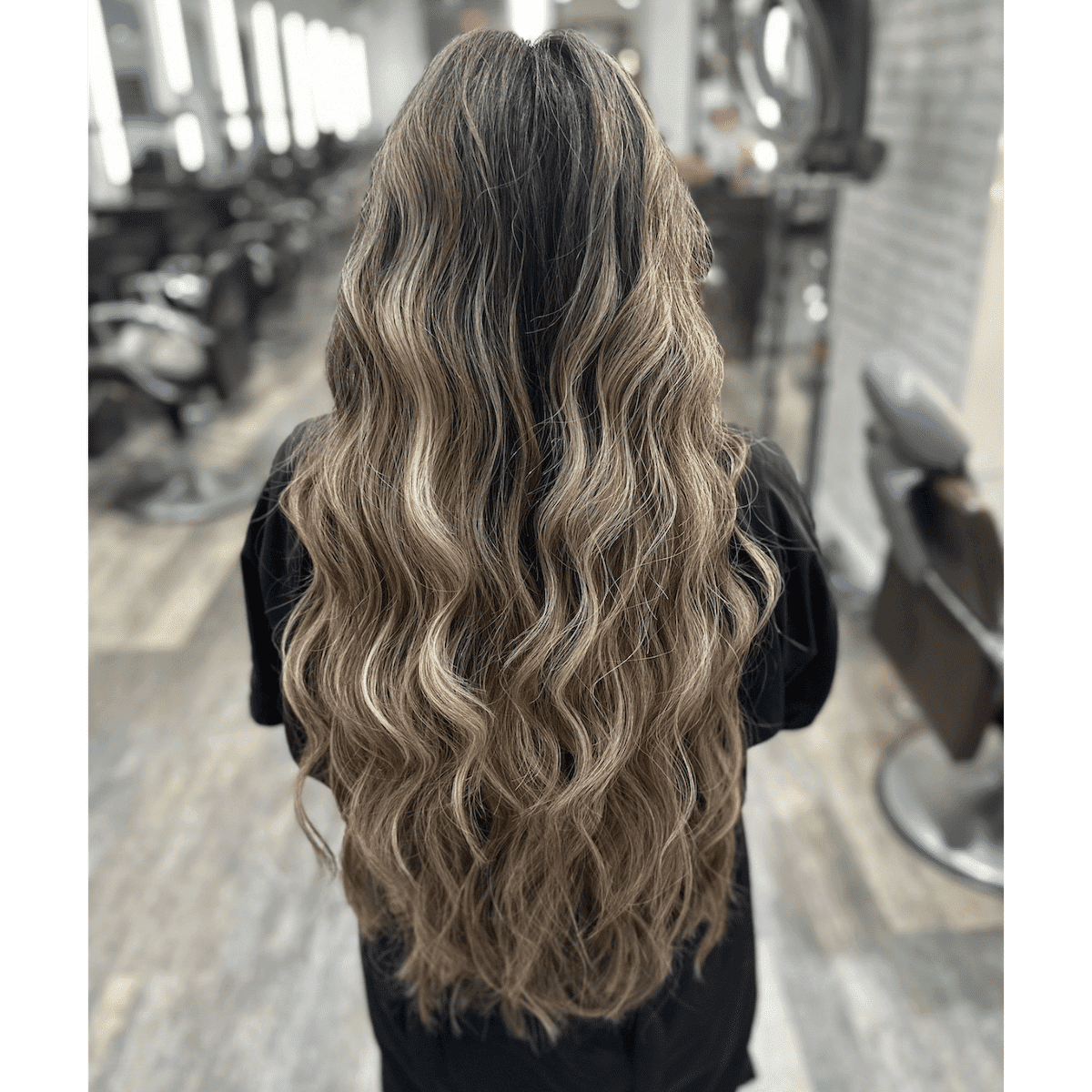 Long, wavy hair styled elegantly in a salon setting.