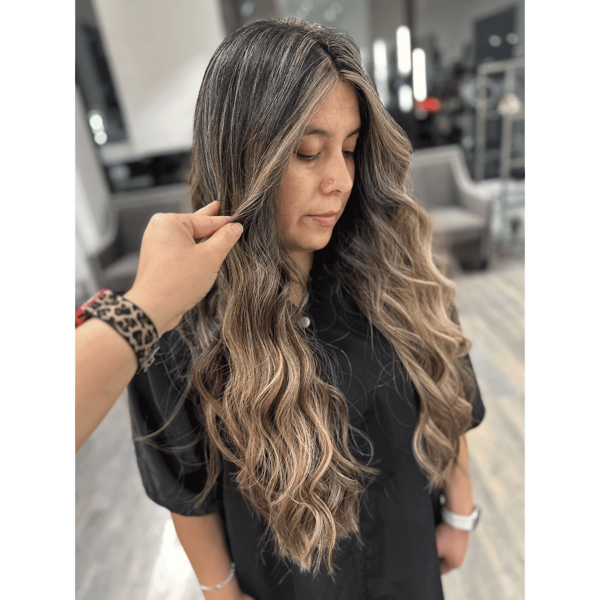 Long wavy hair with highlights, styled in a salon setting.