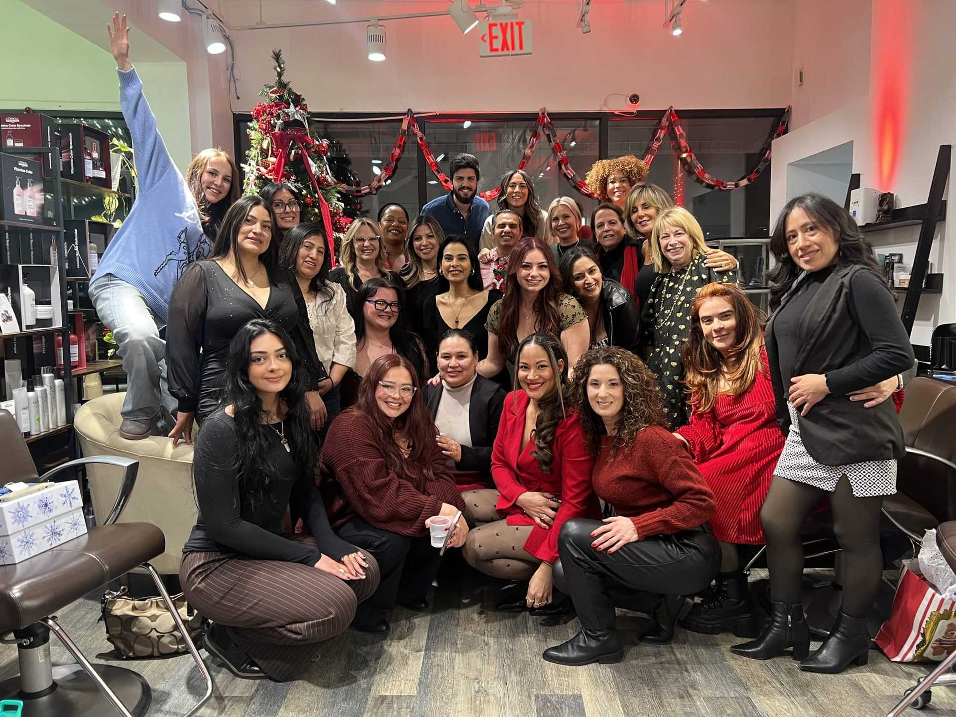 Group celebrating in a festive, decorated salon with a Christmas tree in the background.
